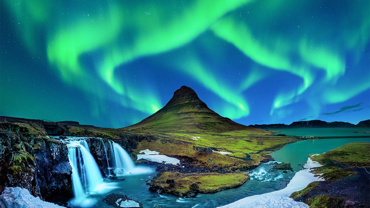 The Aurora Borealis, or Northern Lights, over a volcanic landscape in Iceland